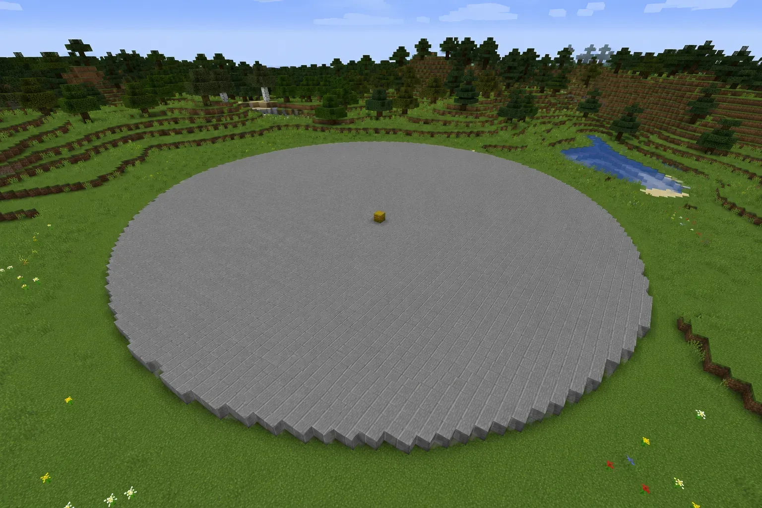 A round solid block circle laid out as an arena floor on a Minecraft plain, reading smooth from a distance