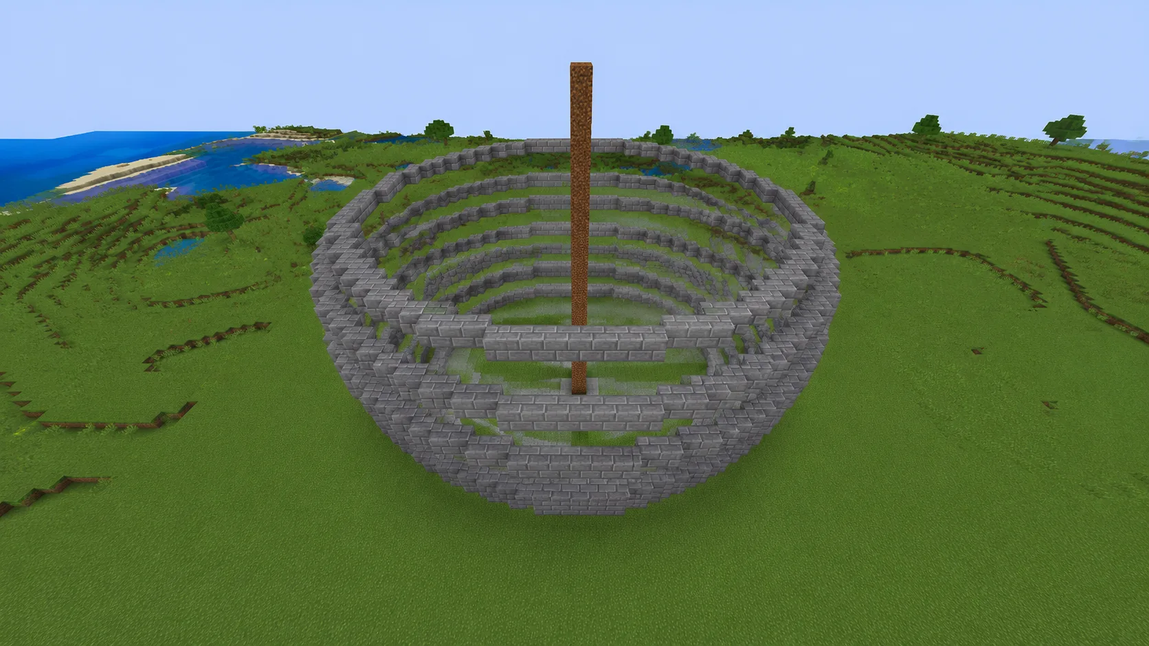 Esfera de Minecraft a medio construir en ladrillos de piedra: anillos inferiores terminados y el anillo del ecuador en progreso